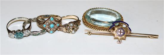 Early 20th century 12ct gold and gem set ring, 3 other 9ct gold gem set rings, an aquamarine brooch & a military brooch / tie pin
